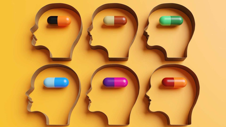 Six patient silhouettes with different colored pills inside each head 